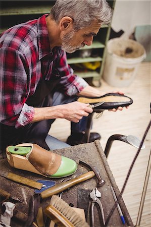 simsearch:6109-08582278,k - Profile view of cobbler using knife on a shoe Stock Photo - Premium Royalty-Free, Code: 6109-08582284