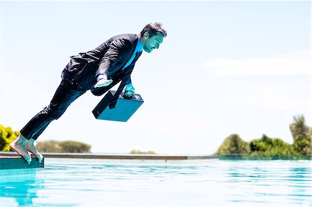 simsearch:6109-06684997,k - Businessman jumping in the swimming pool Stock Photo - Premium Royalty-Free, Code: 6109-08536455