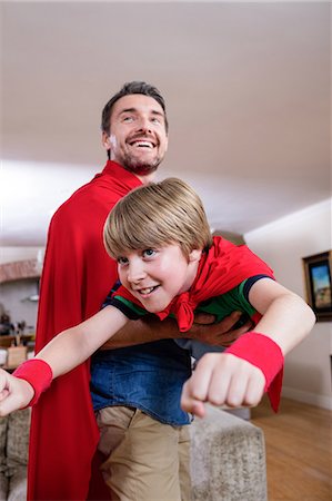 Father and son pretending to be superhero in living room Stock Photo - Premium Royalty-Free, Code: 6109-08536470