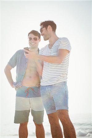 posed - Friends looking at smartphone Stock Photo - Premium Royalty-Free, Code: 6109-08536821