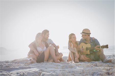simsearch:6109-06781569,k - Cute group of friends sitting on the sand and playing the guitar Stock Photo - Premium Royalty-Free, Code: 6109-08536838