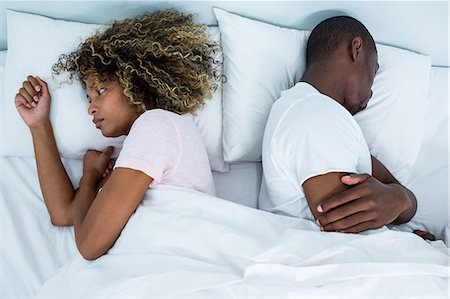 simsearch:6109-07601529,k - Young couple sleeping back to back and ignoring each other Stock Photo - Premium Royalty-Free, Code: 6109-08537140