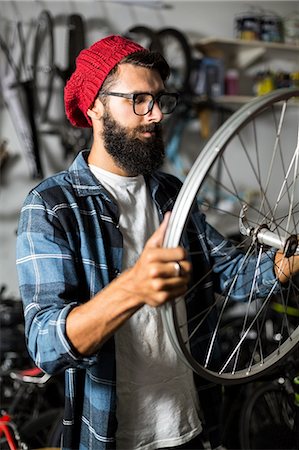 studio - Bike mechanic checking at wheel Photographie de stock - Premium Libres de Droits, Code: 6109-08537276