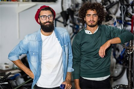 Hipster bike mechanic standing looking serious Foto de stock - Sin royalties Premium, Código: 6109-08537299