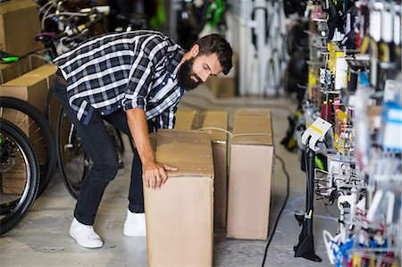 Casual hipster picking up box delivery Stock Photo - Premium Royalty-Free, Code: 6109-08537224