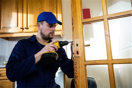 repairman - Manual worker drilling a hole in kitchen Stock Photo - Premium Royalty-Free, Code: 6109-08537540