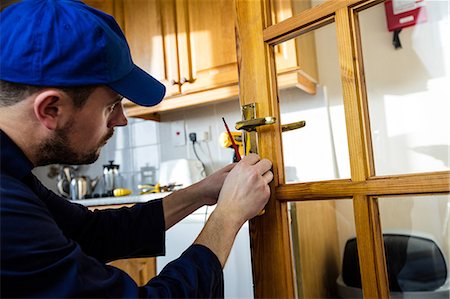 Man fixing the door handle with screwdriver Stock Photo - Premium Royalty-Free, Code: 6109-08537542