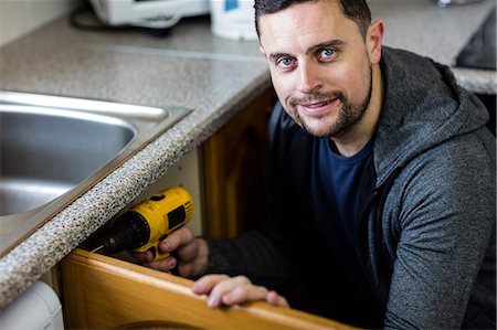 drill (activity) - Portrait of manual worker drilling a hole in kitchen Stock Photo - Premium Royalty-Free, Code: 6109-08537585