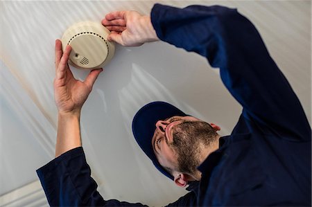 sensor - Handyman installing smoke detector Stock Photo - Premium Royalty-Free, Code: 6109-08537526