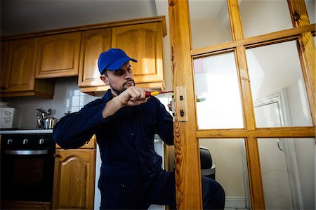 Man fixing the door handle with screwdriver Stock Photo - Premium Royalty-Free, Code: 6109-08537539
