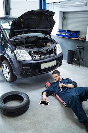 Mechanic using digital tablet while repairing a car Stock Photo - Premium Royalty-Free, Code: 6109-08537635