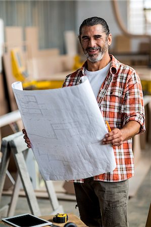 Carpenter holding a blueprint Stock Photo - Premium Royalty-Free, Code: 6109-08537945