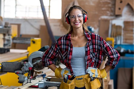 electric saw - Portrait of female carpenter standing with hand on hip Stock Photo - Premium Royalty-Free, Code: 6109-08538053