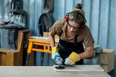 Female carpenter polishing a wooden plank with polishing machine Photographie de stock - Premium Libres de Droits, Code: 6109-08538123