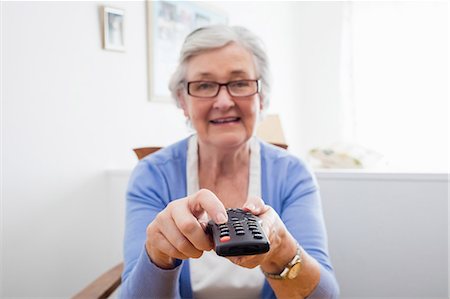 retiree (female) - Senior woman holding a remote control Stock Photo - Premium Royalty-Free, Code: 6109-08538212