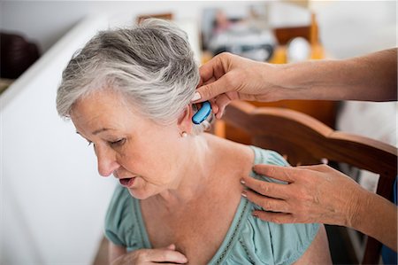 fit people - Nurse putting hearing aid to a senior woman Stock Photo - Premium Royalty-Free, Code: 6109-08538494