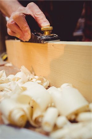 Close-up of carpenter using a sander on a wood plank in his workshop Stock Photo - Premium Royalty-Free, Code: 6109-08689702