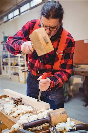 simsearch:6102-07158067,k - Carpenter working on a wooden plan with an hammer in his workplace Stock Photo - Premium Royalty-Free, Code: 6109-08689714