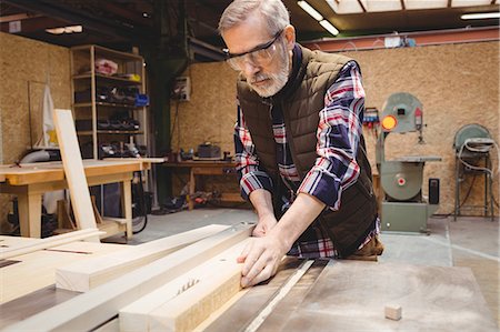 simsearch:6102-07158067,k - Concentrated carpenter cutting a plank of wood in his workshop Stock Photo - Premium Royalty-Free, Code: 6109-08689726