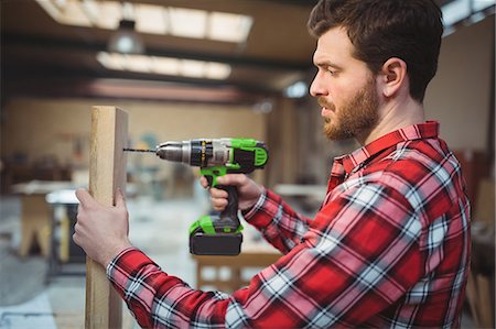 simsearch:6102-07158067,k - Carpenter drilling a hole in a wooden board at the workshop Stock Photo - Premium Royalty-Free, Code: 6109-08689964
