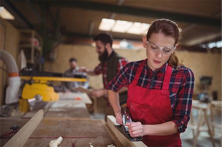 sawing - Female carpenter leveling a timber with jack plane in workshop Stock Photo - Premium Royalty-Free, Code: 6109-08689907