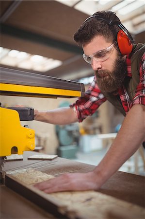 simsearch:6102-07158067,k - Carpenter cutting wooden plank with circular saw in workshop Stock Photo - Premium Royalty-Free, Code: 6109-08689927