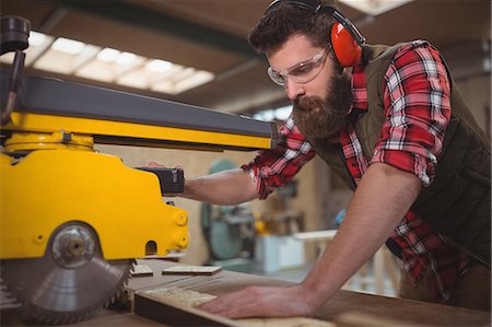 simsearch:6102-07158067,k - Carpenter cutting wooden plank with circular saw in workshop Stock Photo - Premium Royalty-Free, Code: 6109-08689926