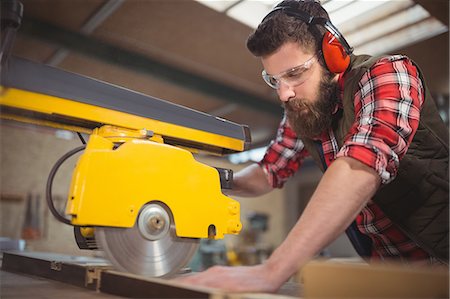 simsearch:6102-07158067,k - Carpenter cutting wooden plank with circular saw in workshop Stock Photo - Premium Royalty-Free, Code: 6109-08689928