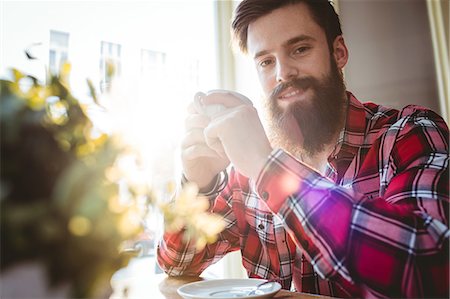 Portrait of happy hipster with coffee at cafe Stock Photo - Premium Royalty-Free, Code: 6109-08690354