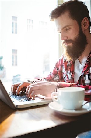 simsearch:6109-08690411,k - Confident young hipster using laptop at cafe Stock Photo - Premium Royalty-Free, Code: 6109-08690358
