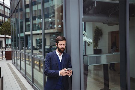 dependable - Businessman using mobile phone outside office Stock Photo - Premium Royalty-Free, Code: 6109-08763993