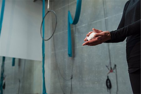 Gymnast rubbing chalk powder on her hands in fitness studio Stock Photo - Premium Royalty-Free, Code: 6109-08764237