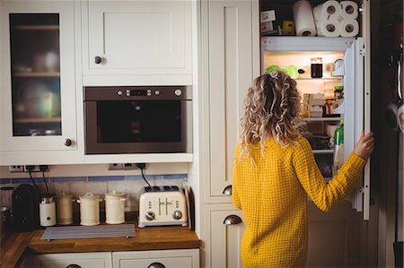 rolled up (closely coiled) - Woman looking for food in refrigerator in kitchen at home Stock Photo - Premium Royalty-Free, Code: 6109-08764417