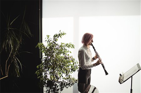 Attentive woman playing a clarinet in music school Stock Photo - Premium Royalty-Free, Code: 6109-08764733