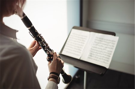 Mid-section of woman playing a clarinet in music school Stock Photo - Premium Royalty-Free, Code: 6109-08764736