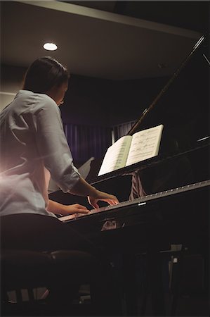 Female student playing piano in a studio Stock Photo - Premium Royalty-Free, Code: 6109-08764987