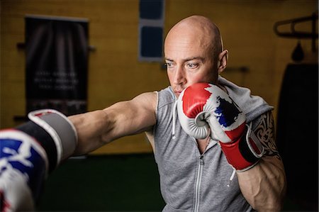 simsearch:400-03984387,k - Thai boxer practicing boxing in the fitness studio Stock Photo - Premium Royalty-Free, Code: 6109-08765056
