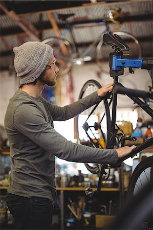 Mechanic examining a bicycle in bicycle workshop Stock Photo - Premium Royalty-Free, Code: 6109-08782901