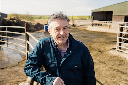 Portrait of mature farmer leaning on fence at field Stock Photo - Premium Royalty-Free, Code: 6109-08700347