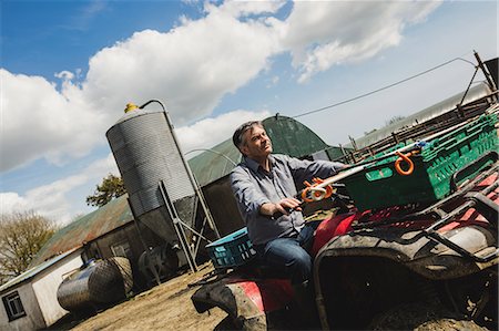 farm workers - Tilt image of farmer riding quadbike at field against sky Stock Photo - Premium Royalty-Free, Code: 6109-08700351