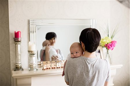 simsearch:6109-08390041,k - Mother carrying her baby and standing in front of mirror at home Stock Photo - Premium Royalty-Free, Code: 6109-08700740