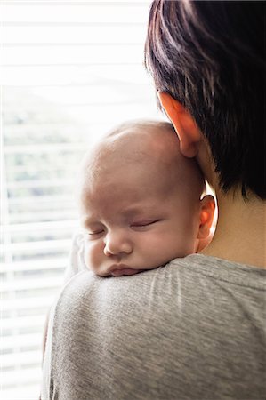 simsearch:6109-08390041,k - Mother holding her little baby and looking through window at home Stock Photo - Premium Royalty-Free, Code: 6109-08700744