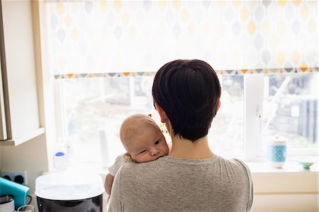 simsearch:6109-08390041,k - Mother holding her little baby in kitchen at home Stock Photo - Premium Royalty-Free, Code: 6109-08700746