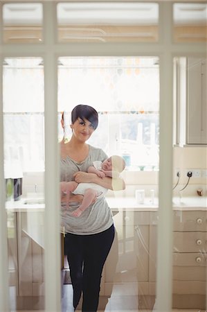 simsearch:6109-08390041,k - Portrait of mother holding her little baby in kitchen at home Stock Photo - Premium Royalty-Free, Code: 6109-08700751