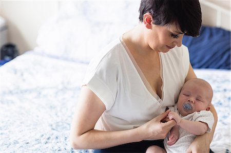 simsearch:6109-08390041,k - Baby with dummy sleeping in mother's arms at home Stock Photo - Premium Royalty-Free, Code: 6109-08700768