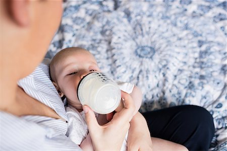 simsearch:6109-08390041,k - Mother feeding baby with milk bottle in bedroom at home Stock Photo - Premium Royalty-Free, Code: 6109-08700773