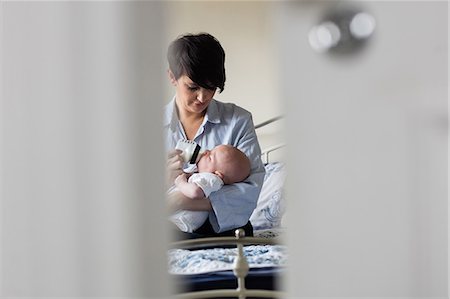 simsearch:6109-08390041,k - Mother feeding baby with milk bottle in bedroom at home Stock Photo - Premium Royalty-Free, Code: 6109-08700772