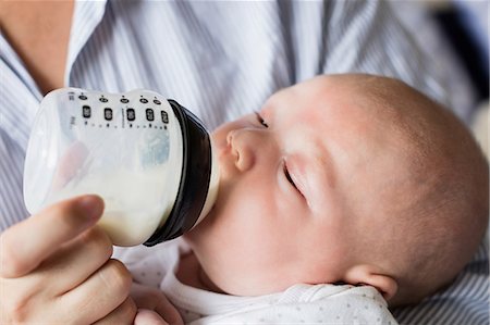 simsearch:6109-08390041,k - Close -up of mother feeding baby with milk bottle at home Stock Photo - Premium Royalty-Free, Code: 6109-08700774