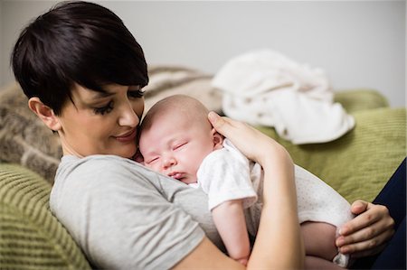 simsearch:6109-08390041,k - Mother holding baby while sleeping in living room at home Stock Photo - Premium Royalty-Free, Code: 6109-08700730