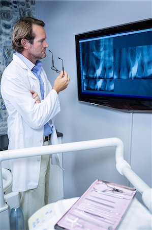 simsearch:614-06813654,k - Thoughtful dentist examining an x-ray on the monitor in clinic Foto de stock - Sin royalties Premium, Código: 6109-08700854